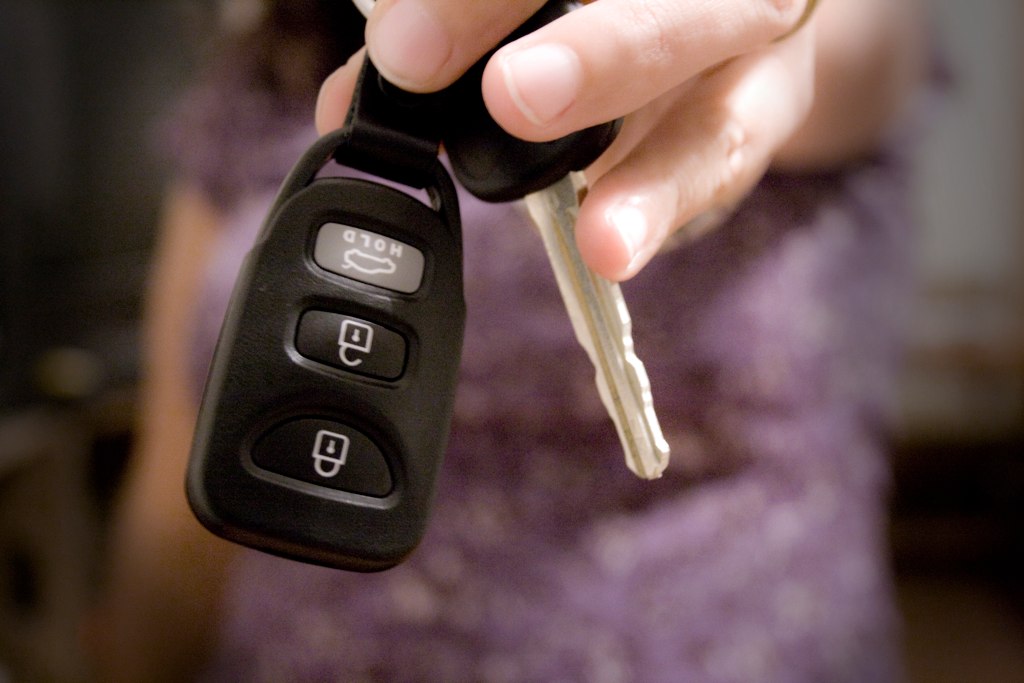 Hand holding a modern car key fob