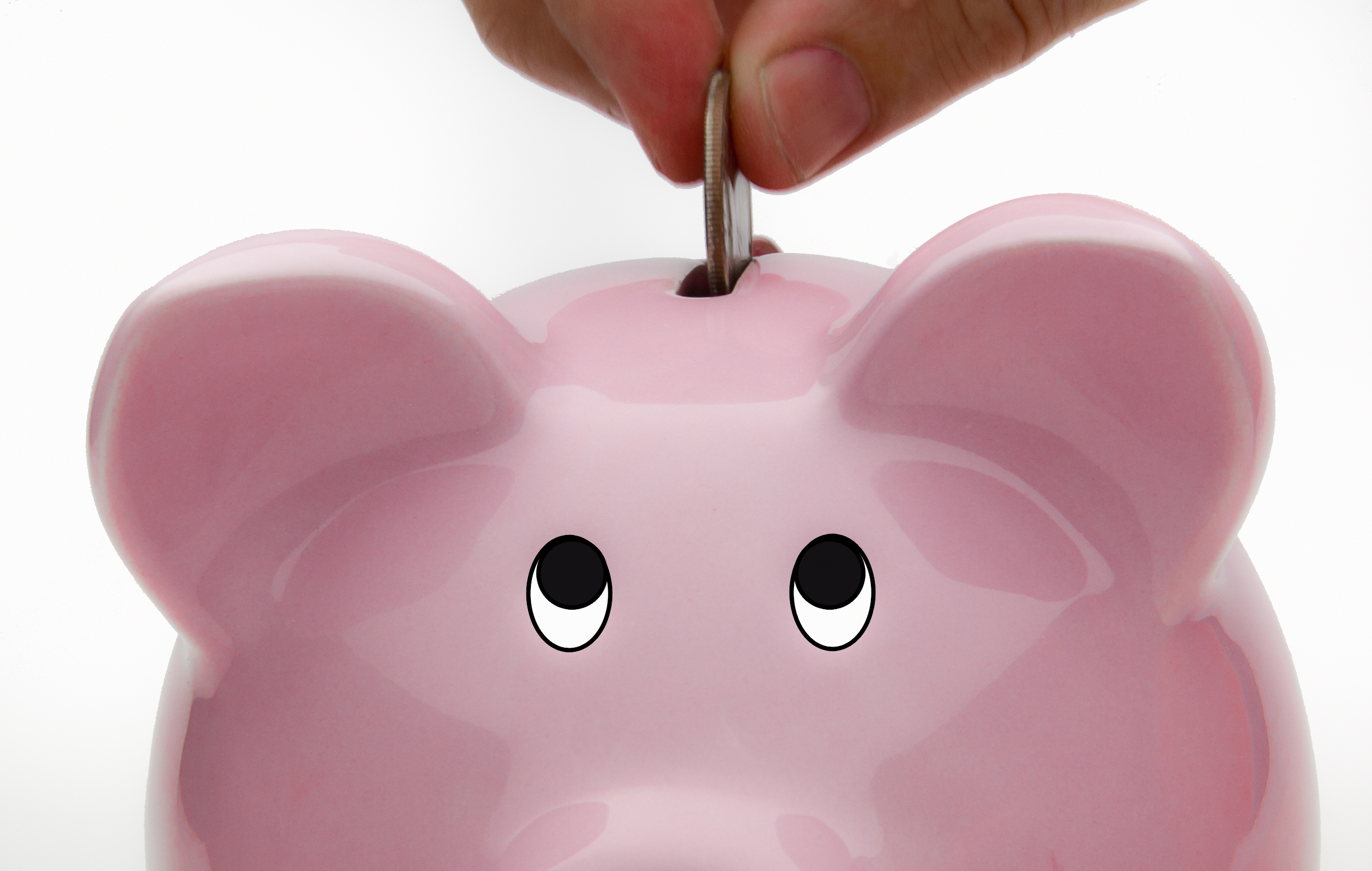 Hand dropping a coin into a pink ceramic piggy bank against a white background, representing savings and bank account deposits